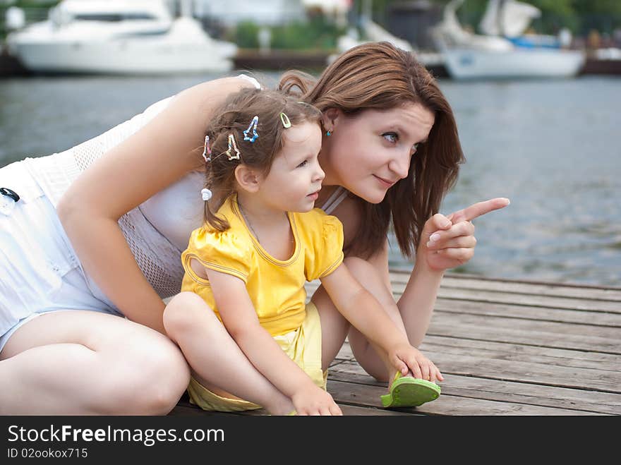 Mother and daughter sitting on pier of the yacht club. Mother and daughter sitting on pier of the yacht club.