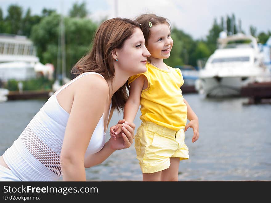 Mother and daughter sitting on pier of the yacht club. Mother and daughter sitting on pier of the yacht club.