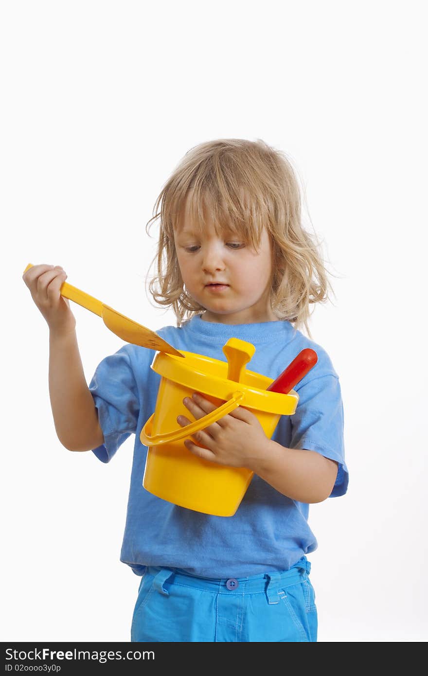 Boy with long blond hair carrying colorful plastic beach toys - isolated on white. Boy with long blond hair carrying colorful plastic beach toys - isolated on white