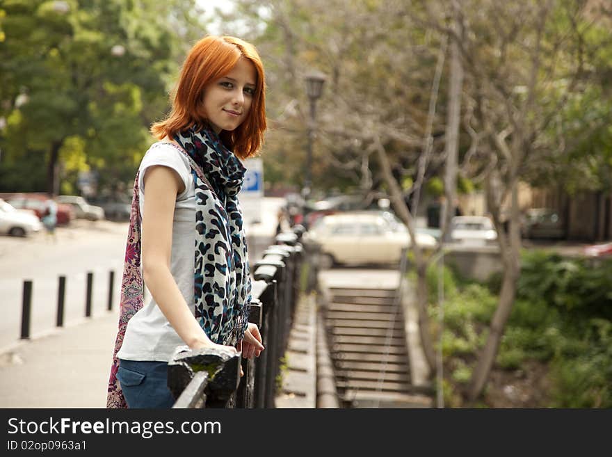 Portrait of beautiful red-haired girl. Outdoor photo.