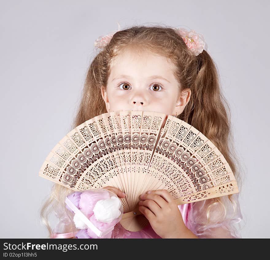 Portrait of beautiful young girl with fan. Studio shot.