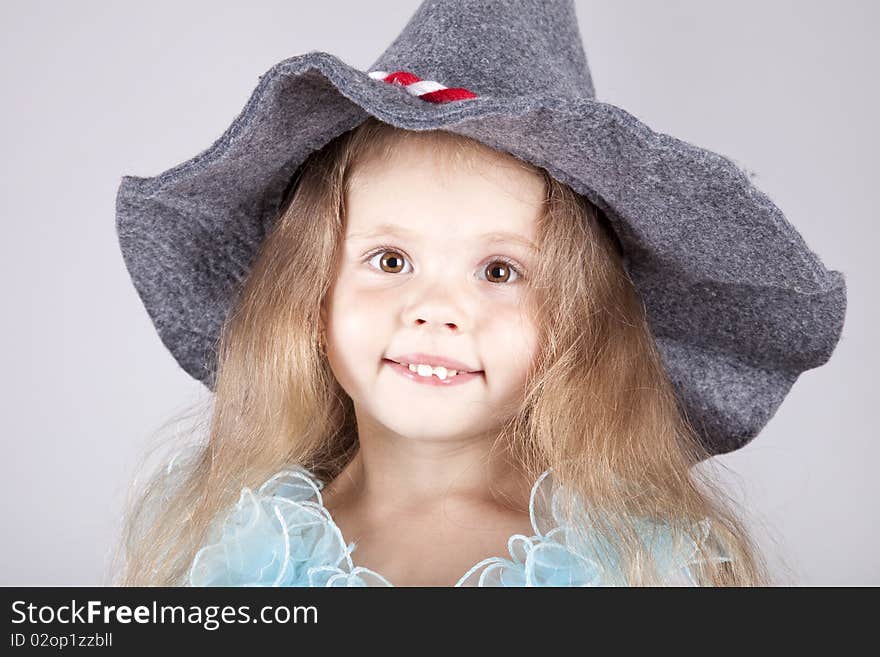 Beautiful young smiling girl in cap. Studio shot.