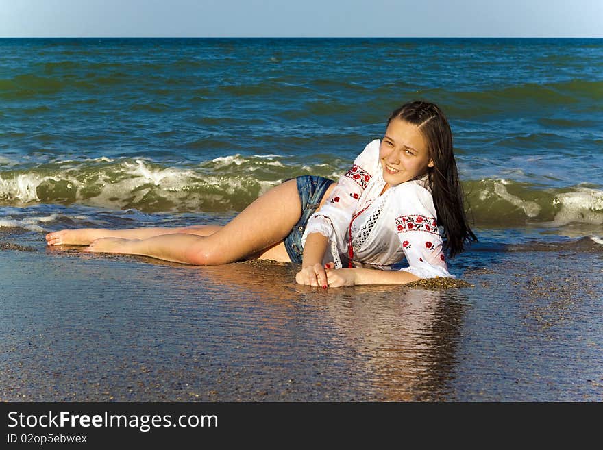 Happy girl in shorts and a white shirt on the sea. Happy girl in shorts and a white shirt on the sea