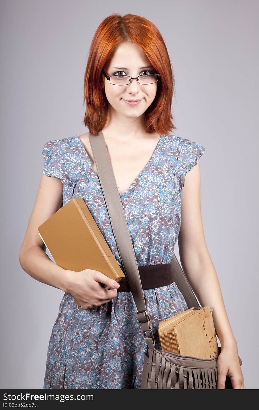 Red-haired girl keep book in hand.