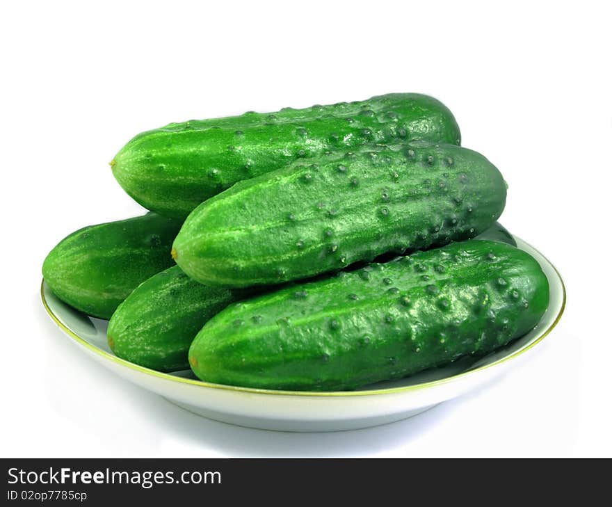 Five fresh cucumbers on a saucer