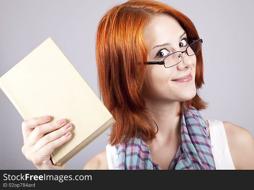 Red-haired girl keep book in hand.