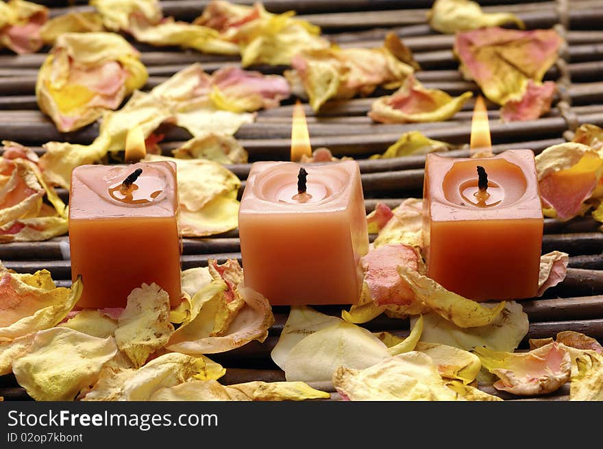 Row of red candle with petals on mat. Row of red candle with petals on mat