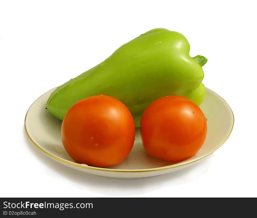 Sweet pepper and two tomatoes on a saucer