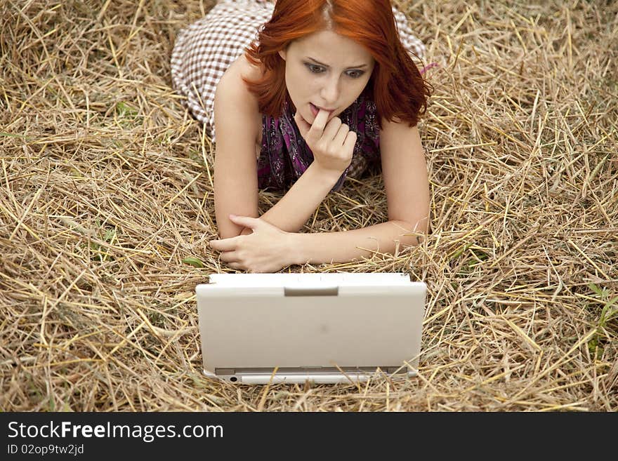 Young  fashion girl with notebook lying at field. Outdoor shot.