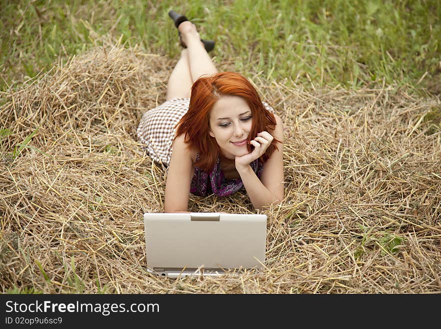 Young  fashion girl with notebook lying at field. Outdoor shot.