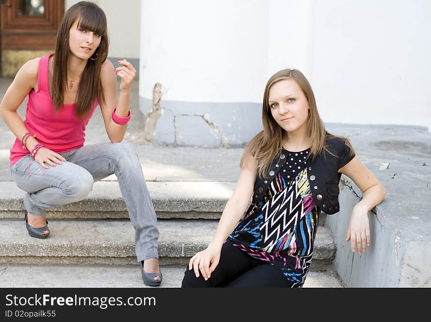 Two female friends sitting on stairs