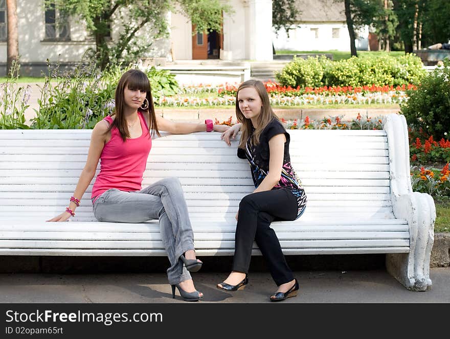 Two female friends sitting on bench