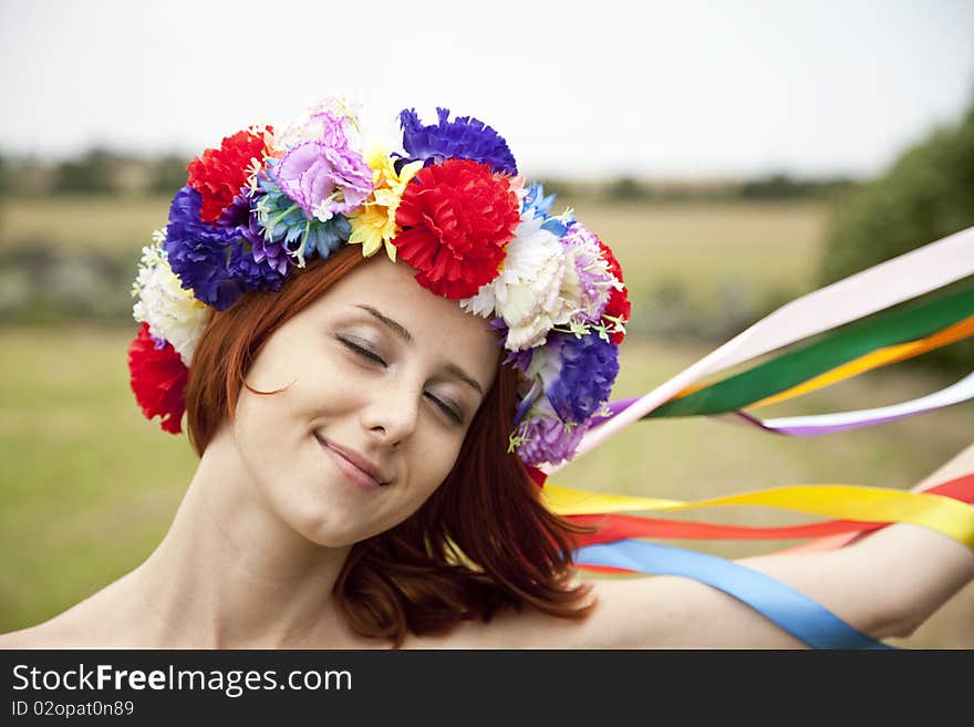 Slav girl with wreath at field