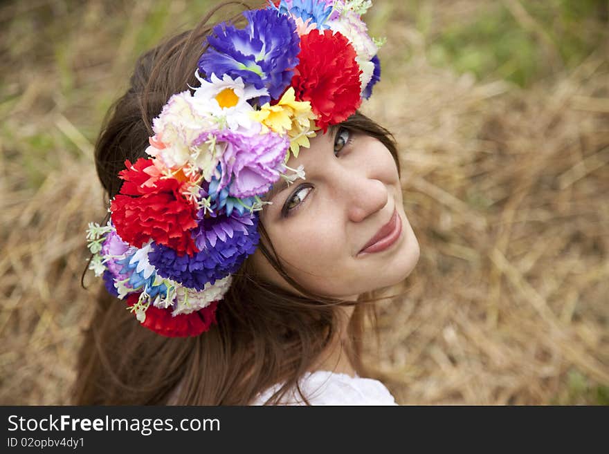 Slav girl with wreath at field