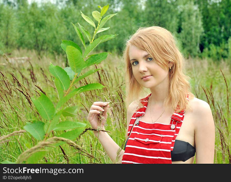 The beautiful girl with blue eyes in a grass