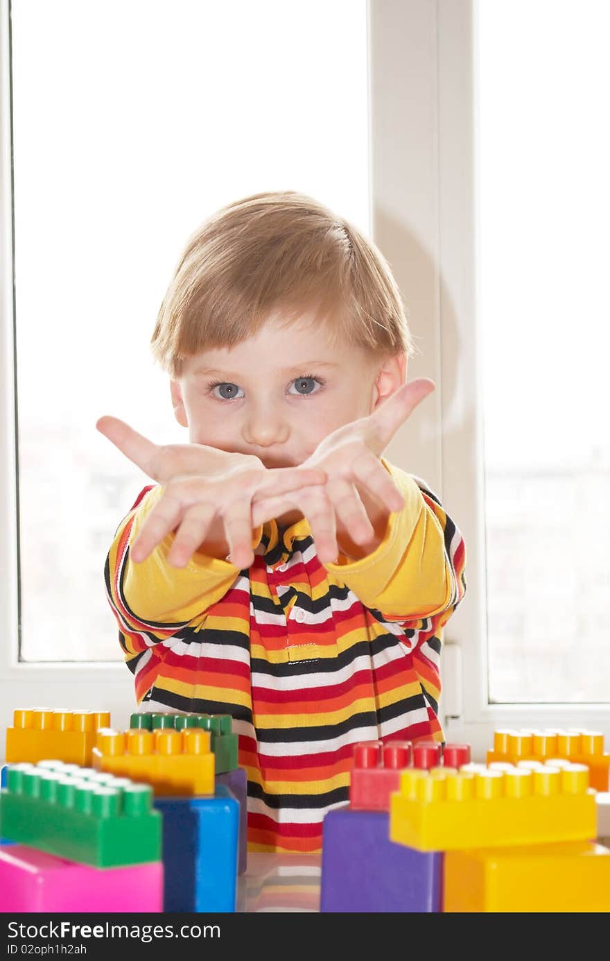 The beautiful little boy poses on a light background. The beautiful little boy poses on a light background