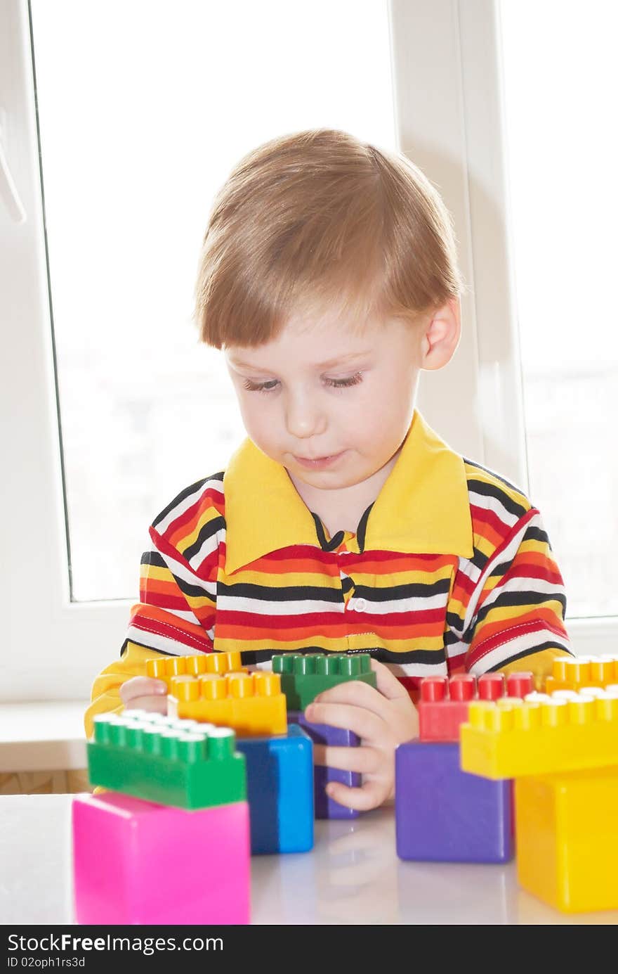 The beautiful little boy poses on a light background. The beautiful little boy poses on a light background