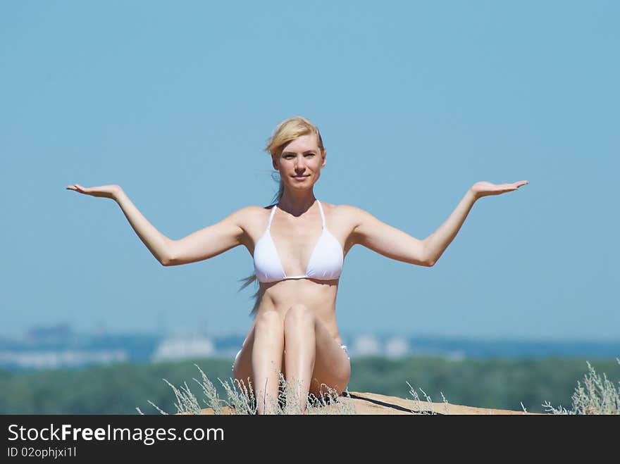 The girl in meditation on a background of the dark blue sky in the summer. The girl in meditation on a background of the dark blue sky in the summer