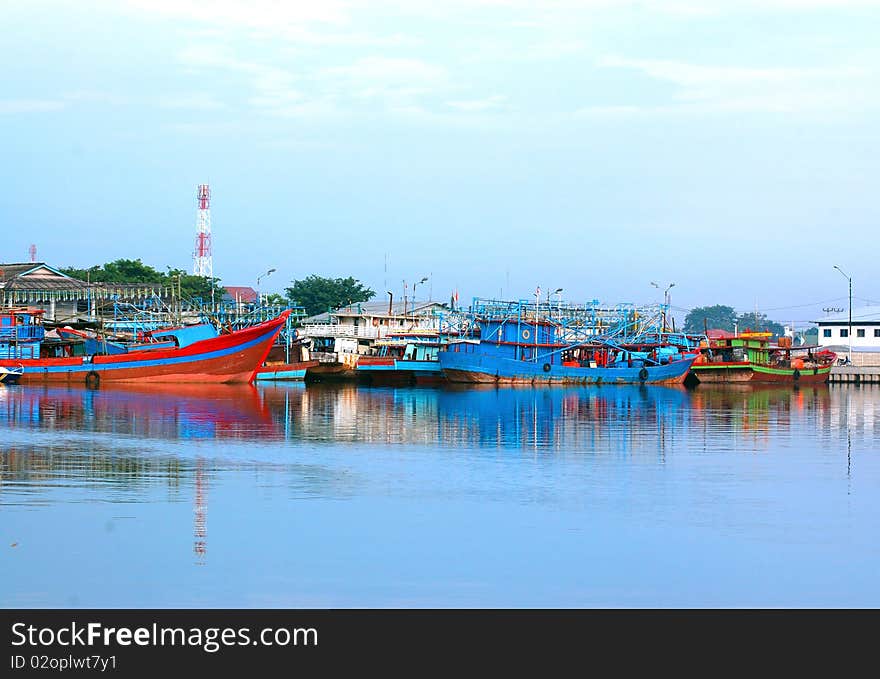 A scenery of a dock side, with many wooden boat on docks