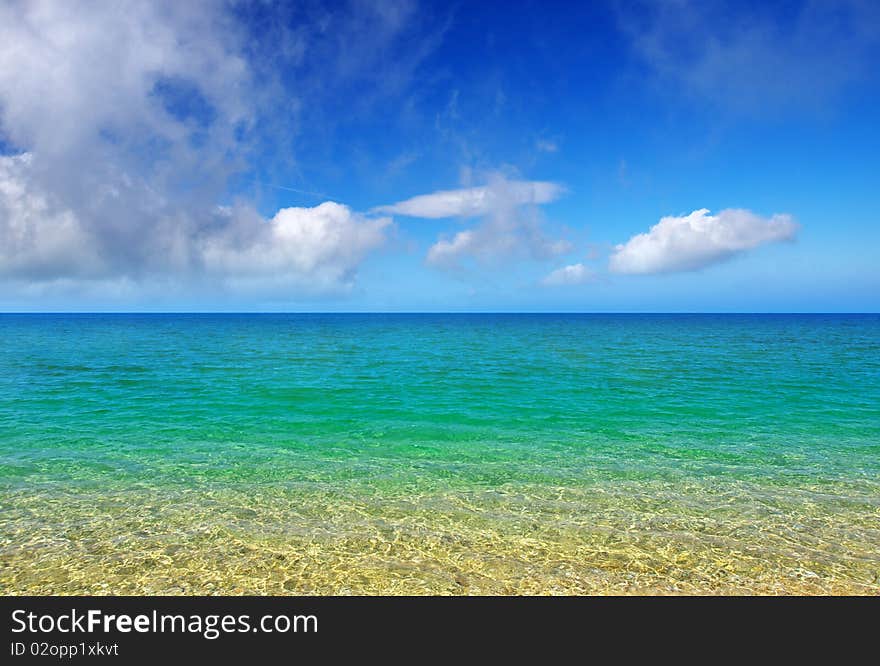 Turquoise sea and blue bright sky with cloud.