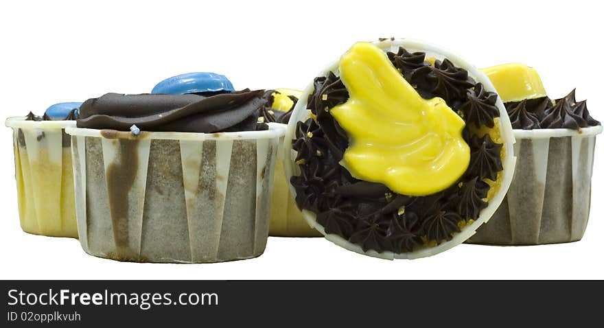 Several cupcake with yellow, blue and chocolate topping, one facing camera, and the rest facing upwards