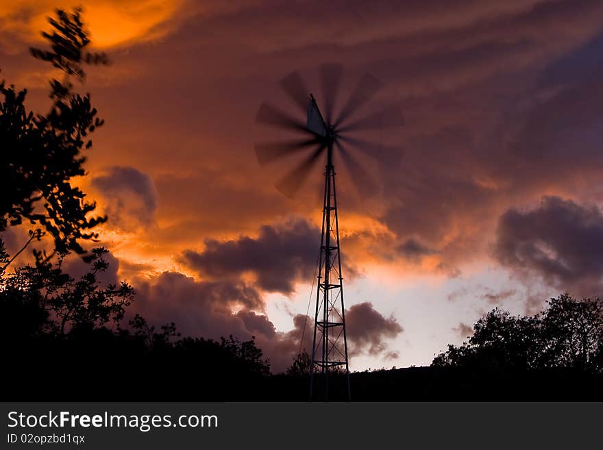 Windmill in a storm threatening sunset