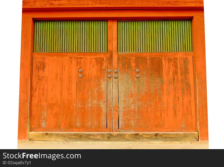 A large, worn, orange and green gate to a Japanese temple. A large, worn, orange and green gate to a Japanese temple