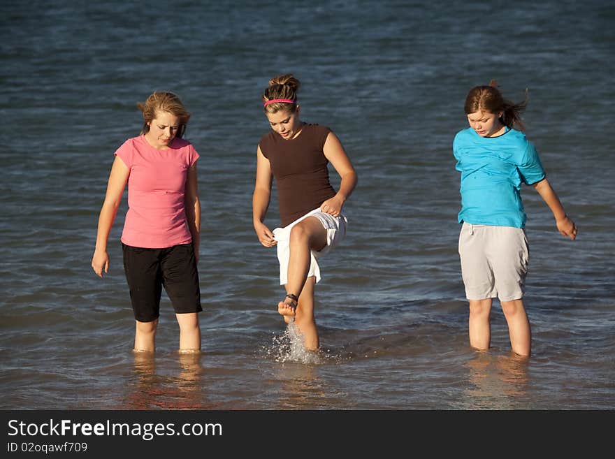 Some teenage girls in the outdoors playing in the water and splashing. Some teenage girls in the outdoors playing in the water and splashing.