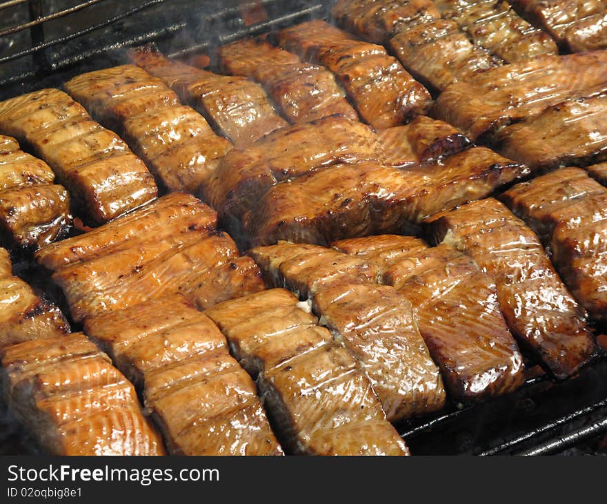 A close up cooking salmon on a outdoor grill to perfection. A close up cooking salmon on a outdoor grill to perfection.