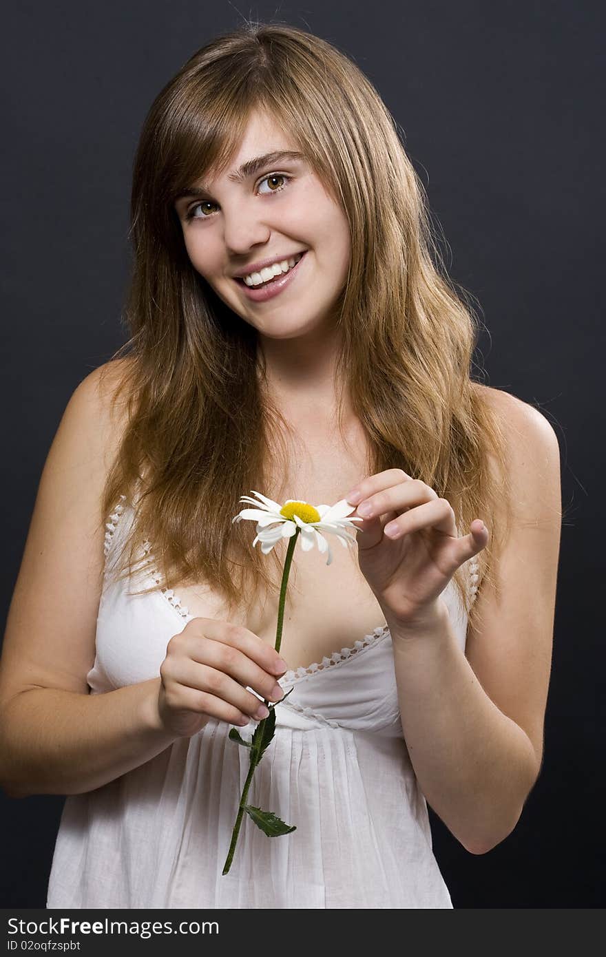 Portrait of fresh and beautiful woman with camomile