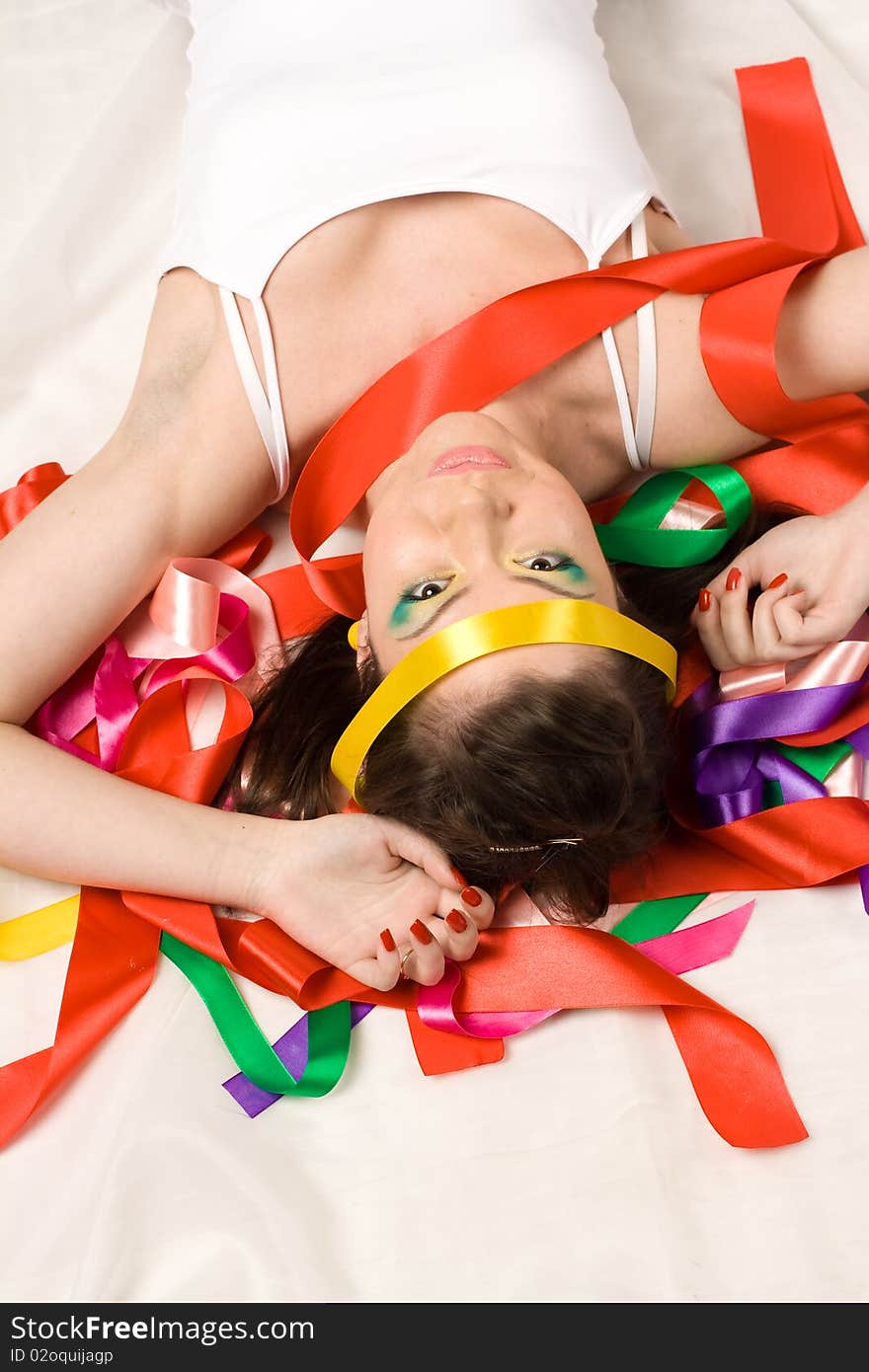 Sexy girl with colourful ribbons in studio on red background. Sexy girl with colourful ribbons in studio on red background