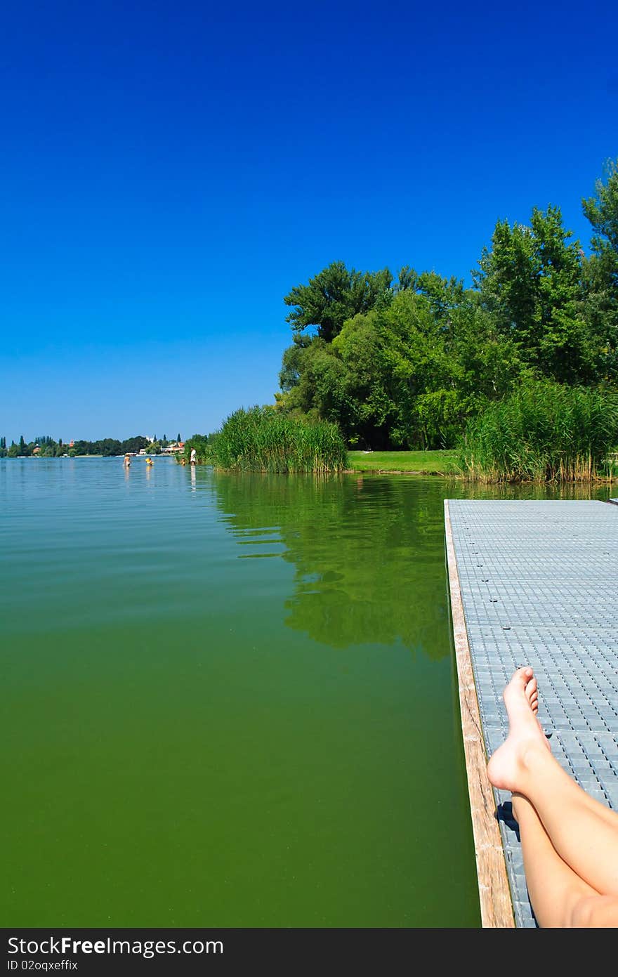 Legs over the green lake in Tata