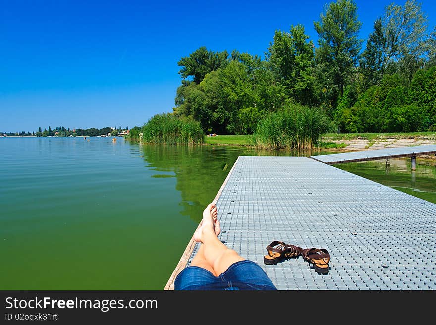 Legs over the green lake in Tata