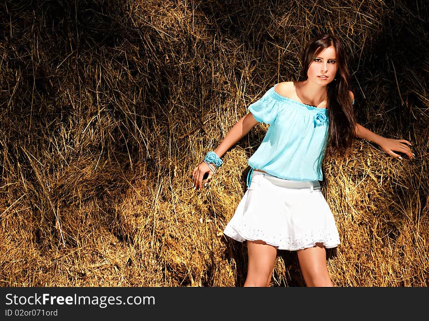 Sexy model standing near haystack.