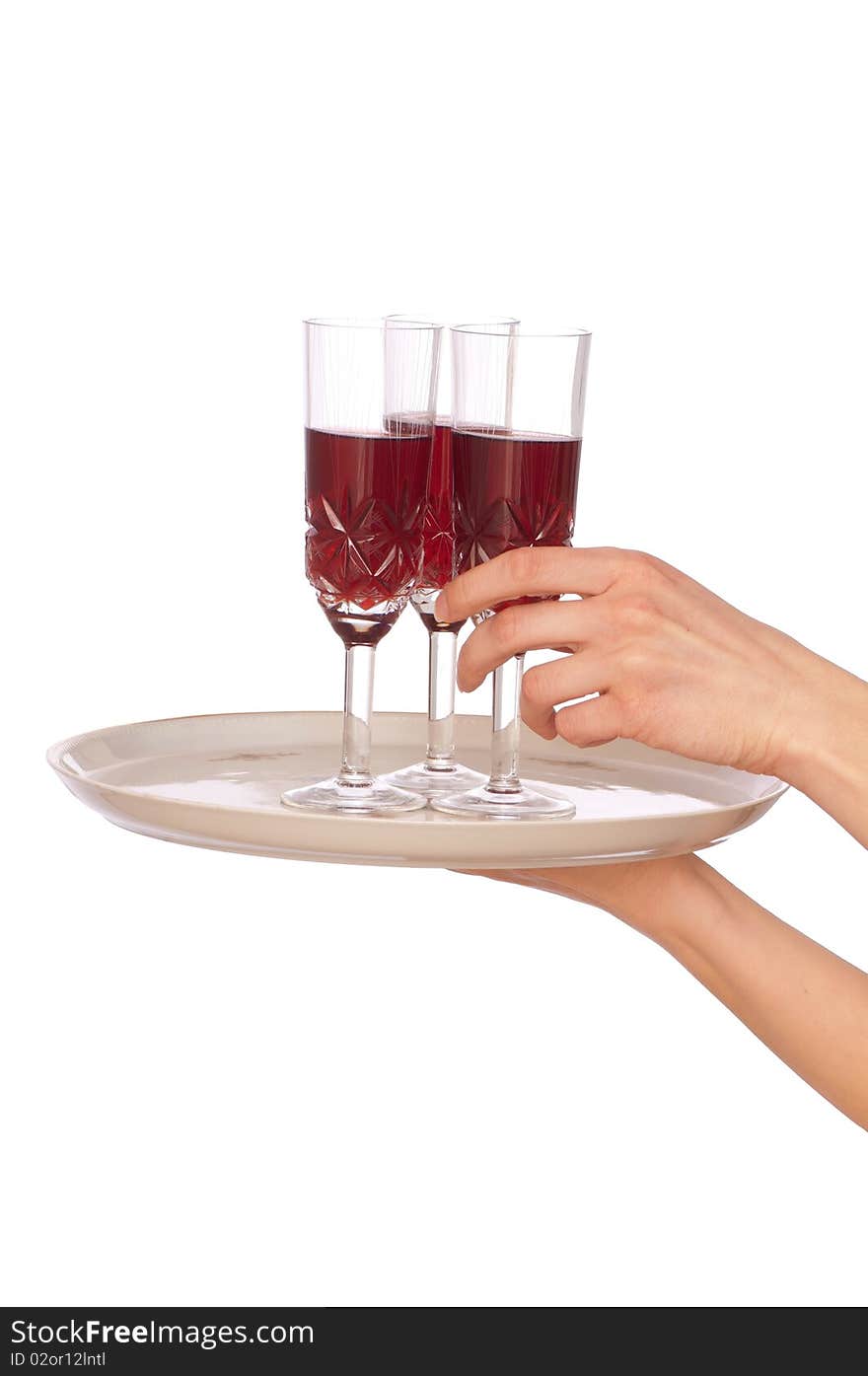 A waiter takes a glass of champagne from a tray with three glasses. A waiter takes a glass of champagne from a tray with three glasses