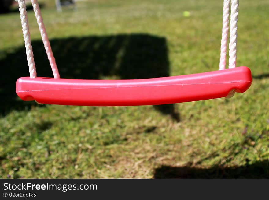 Close up of a plastic swing hanging in the garden