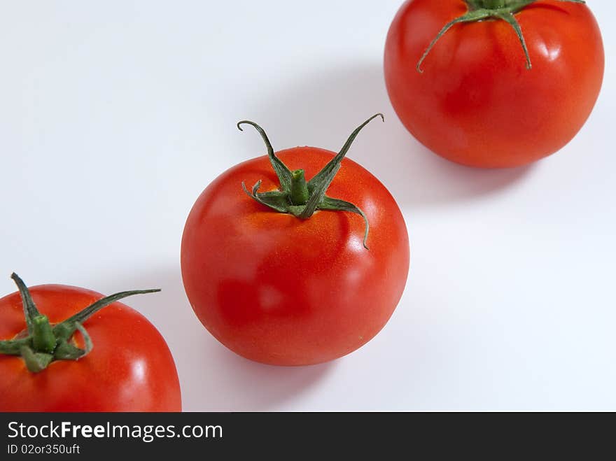 Close up of 3 tomatoes in a white background. Close up of 3 tomatoes in a white background