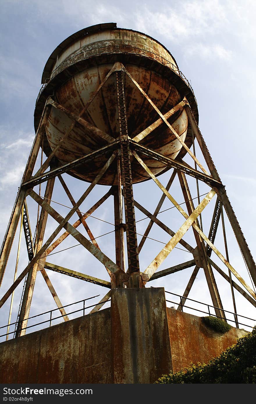 A foreboding marker of the Alcatraz Prison grounds. The massive weathered water tank stands tall with shimmering rust stains in the afternoon sun. A foreboding marker of the Alcatraz Prison grounds. The massive weathered water tank stands tall with shimmering rust stains in the afternoon sun.