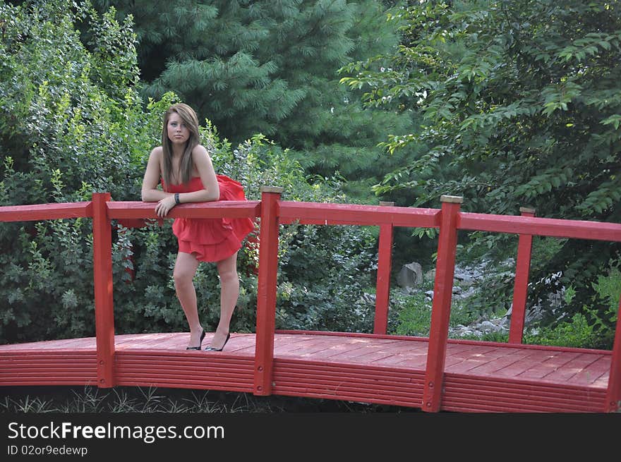 Lady in red standing on a red bridge. Lady in red standing on a red bridge