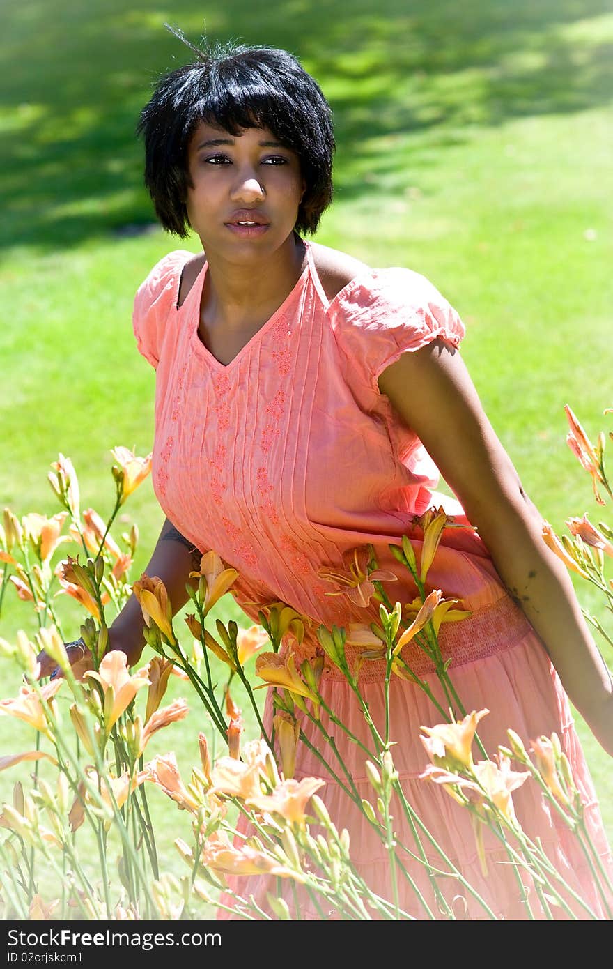 Beautiful black woman standing in flowers. Beautiful black woman standing in flowers