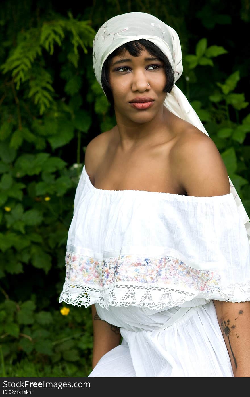 Beautiful black woman wearing scarf on head in nature setting. Beautiful black woman wearing scarf on head in nature setting