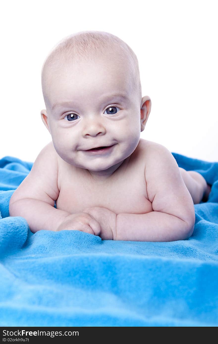 Beautiful baby under a blue towel on white background