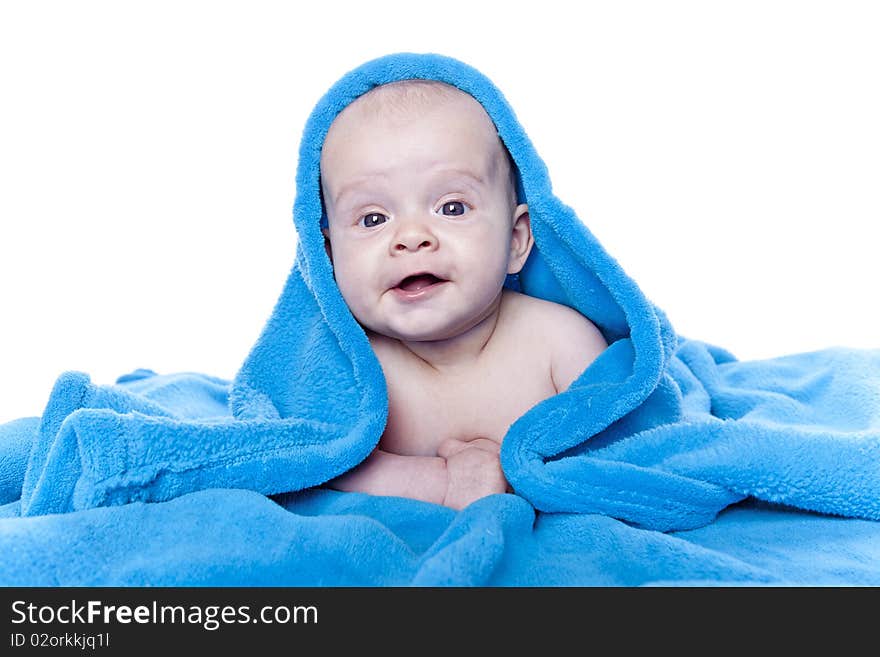 Beautiful baby under a blue towel on white background