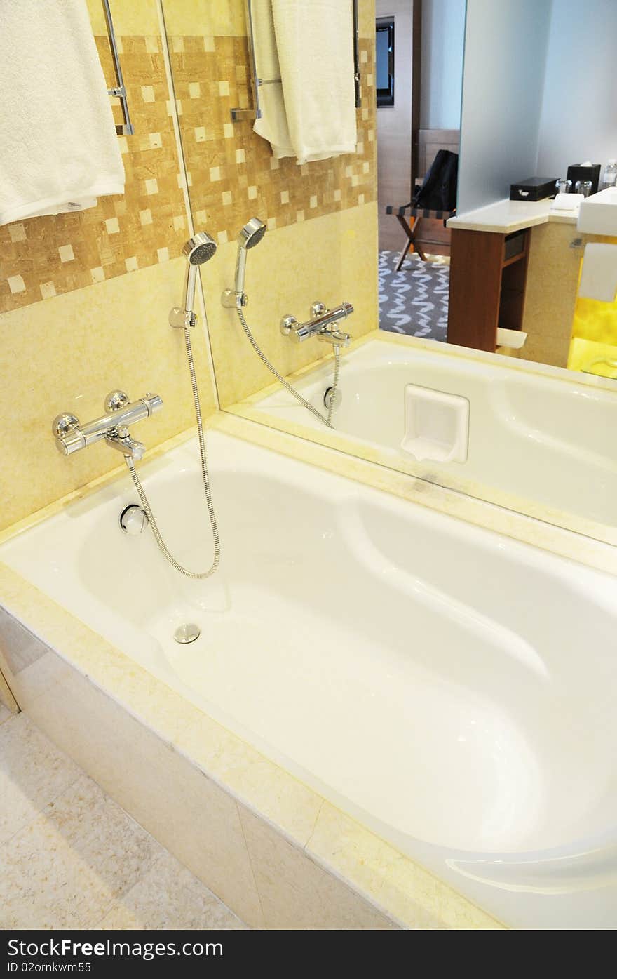 White ceramic bathtub of rectangular shape in the luxury hotel suite. White ceramic bathtub of rectangular shape in the luxury hotel suite.