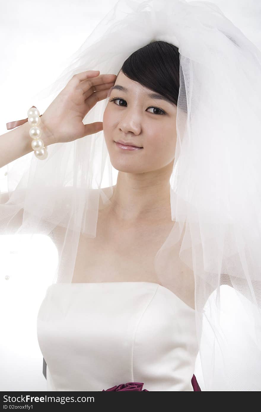 Beautiful bride with perfect natural makeup,smiling,wearing mantilla,pearls round wrist