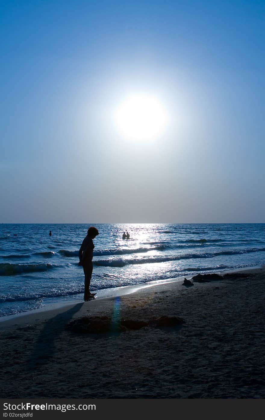 Beautiful sunset on the sea with the silhouettes of people walking on the beach