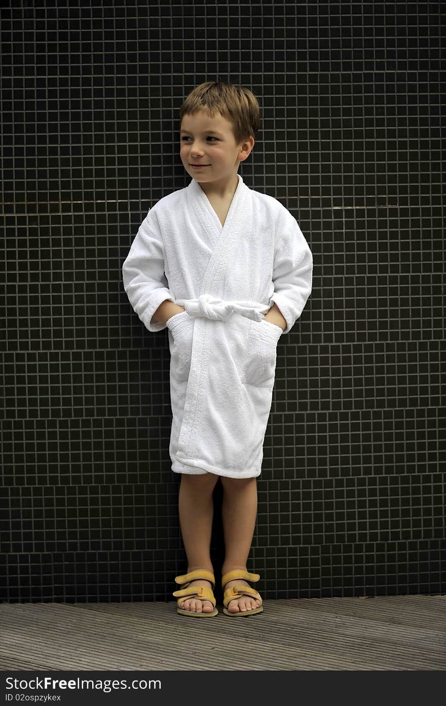 Cute little boy at spa wearing bathrobe