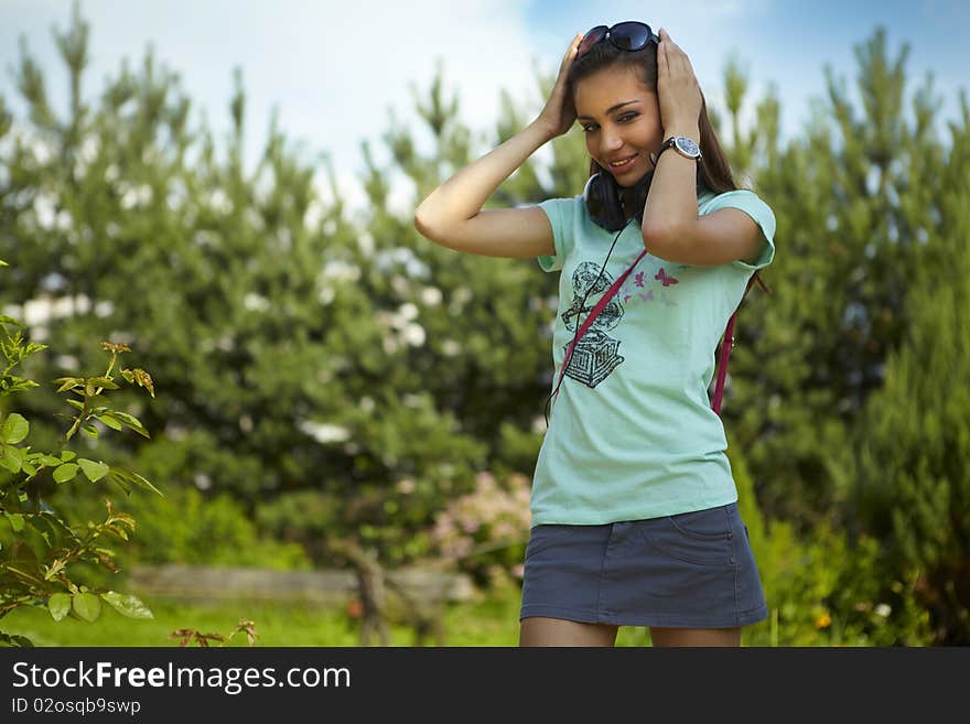 Young Beautiful Girl With Earphones Walking.