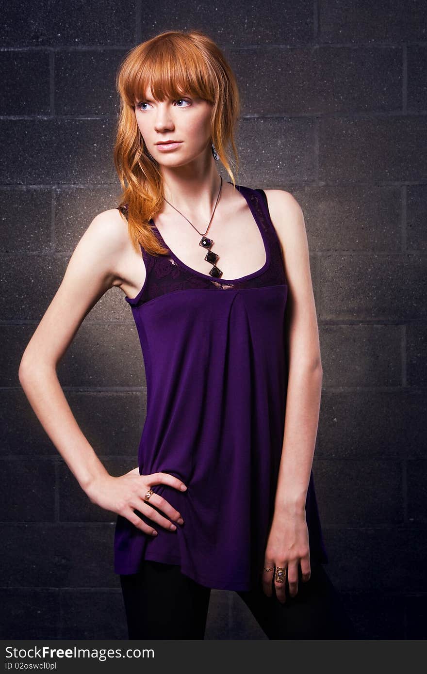 Portrait of a pretty red-haired girl on a brick wall background