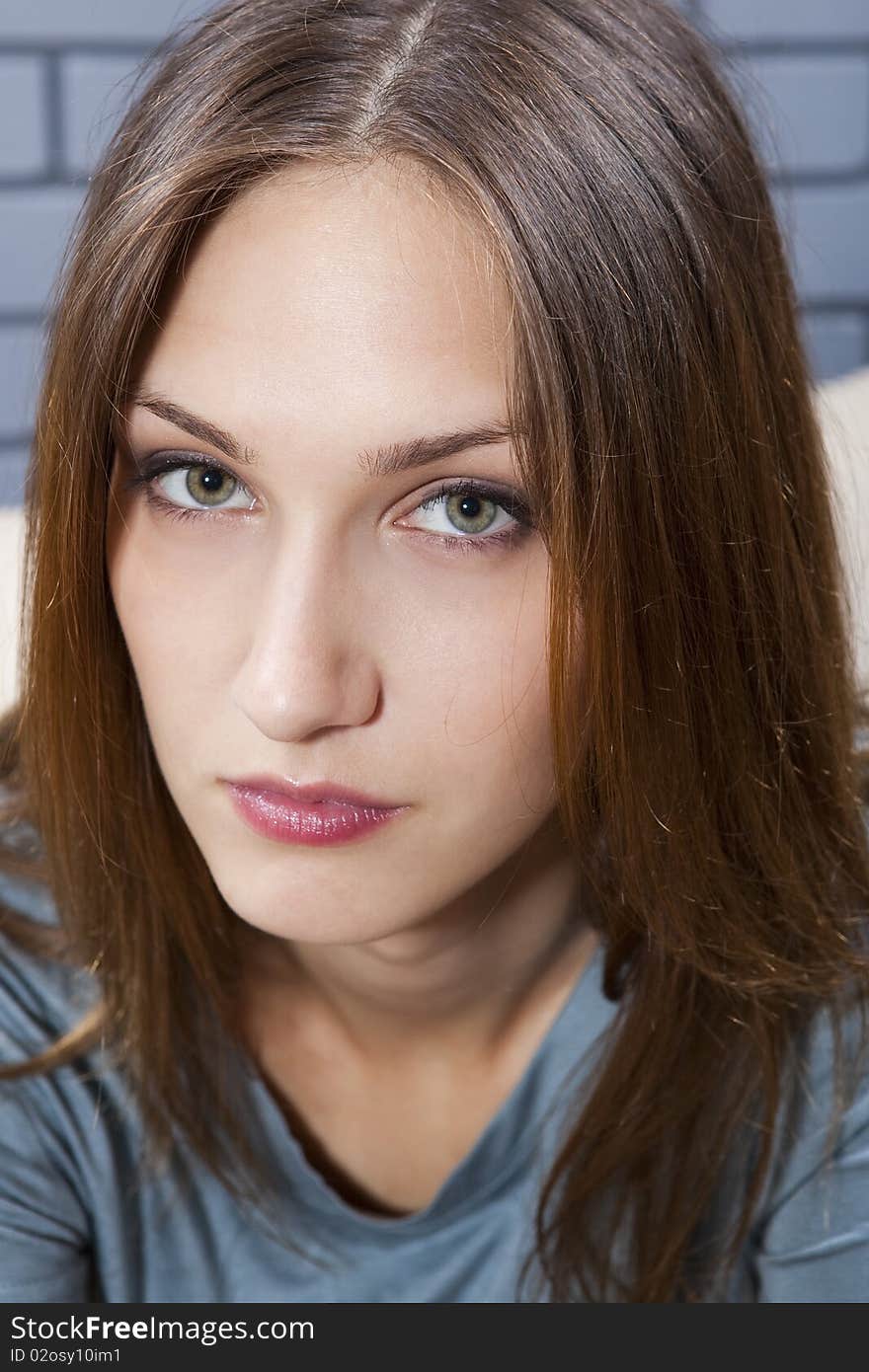 Young female portrait against grey brick wall